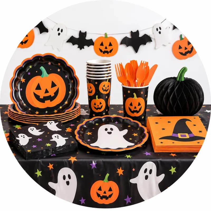 Pumpkin and ghost paper plates, cups, napkins, and a bat garland on a party table